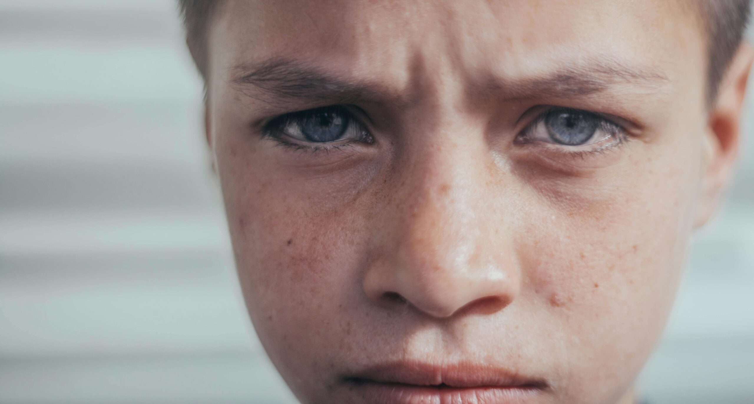 Intense close-up of a young boy's face expressing deep emotion.