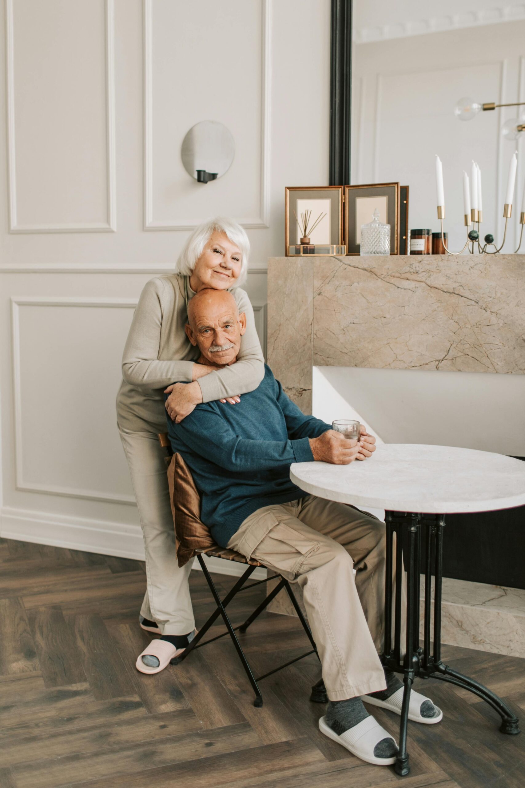 Elderly couple enjoying a warm moment together in their cozy home setting.